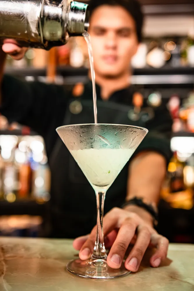 Bartender preparando un cocktail. Mixología artesanal y servicio personalizado en el bar de Rosatto.