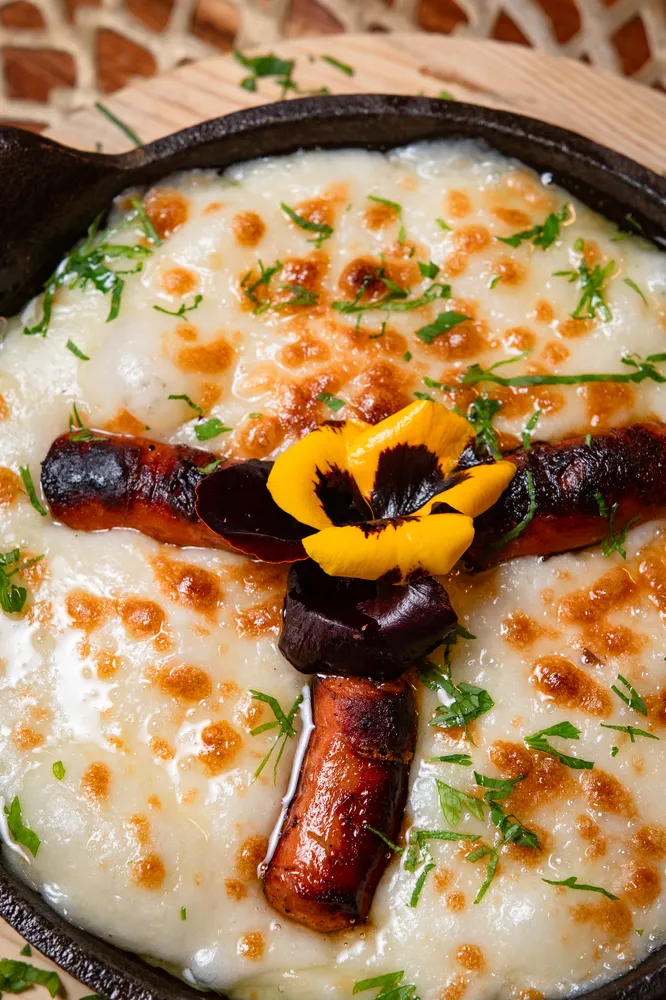 Queso fundido gratinado con chistorra en Rosatto Acapulco